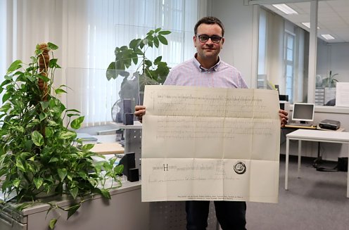 Michael Schütze, Sachbearbeiter Stadtarchiv, mit dem Faksimile der urkundlichen Ersterwähnung Nordhausens (Foto: Stadtverwaltung Nordhausen)